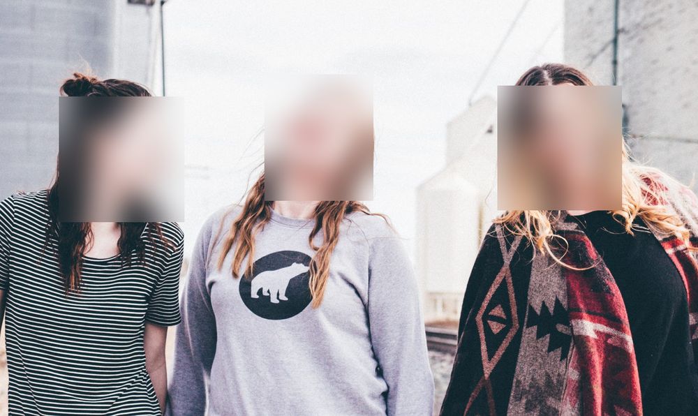 The same three faces blurred, skin tone and head position still visible through the blur